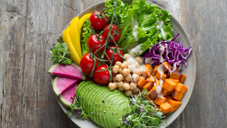 großer Salatteller mit verschiedenem Gemüse und einem Dressing | © Anna Pelzer/unsplash