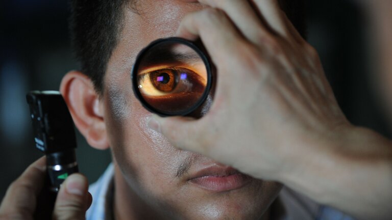 Das Auge eines Mannes wird mit einem Vergrößerungsglas untersucht. | © pixabay