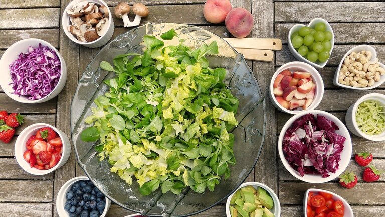 ein Salat im Zentrum, daneben sind Schüsseln mit diversen Obst und Gemüse  | © pixabay