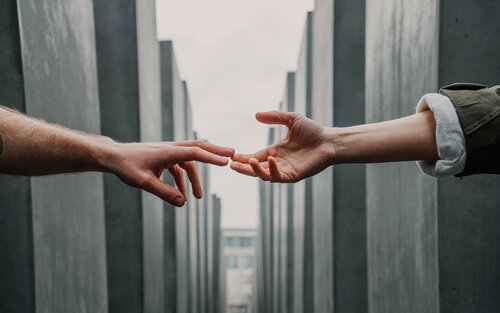 Zwei Hände von verschiedenen Personen, die Fingerspitzen berühren sich | © Toa Heftiba/unsplash