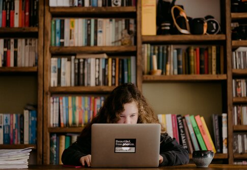 Ein Mädchen sitzt am Schreibtisch und arbeitet am Laptop | © Annie Spratt / unsplash