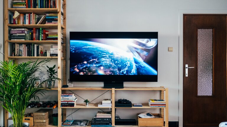 Holzregal mit Büchern und eine Fernsehgerät | © unsplash.de