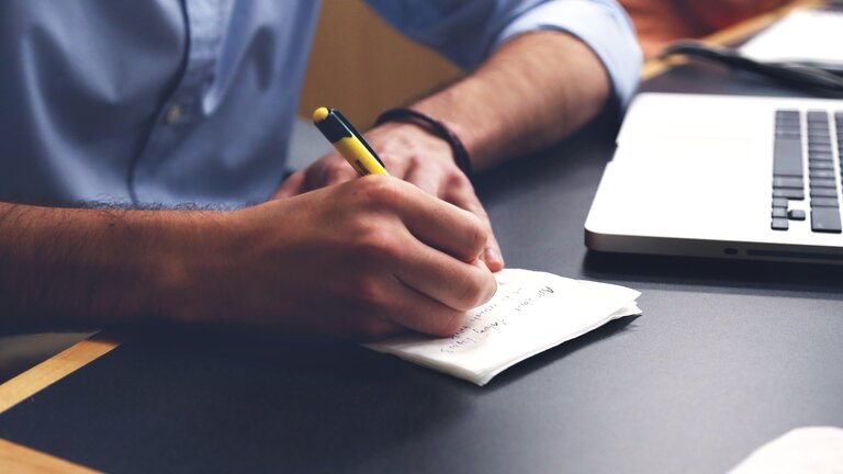 Eine Person schreibt eine Notiz auf einen Zettel | © pixabay