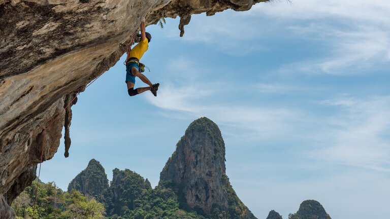 Foto von einem Mann, der an einer Felswand klettert. | © Unsplash