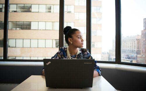 Foto einer Frau, die vor einem Laptop sitzt, aber nach links schaut. Sie wirkt unkonzentriert. | © pexels