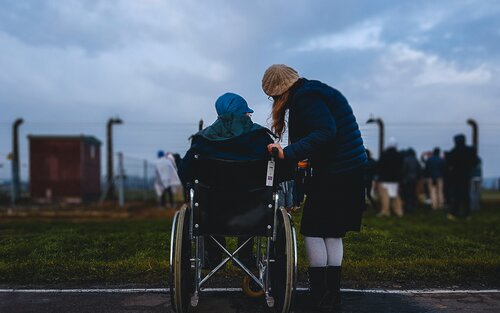 Eine Frau steht neben einem Mann, der im Rollstuhl sitzt | © Josh Appel/unsplash
