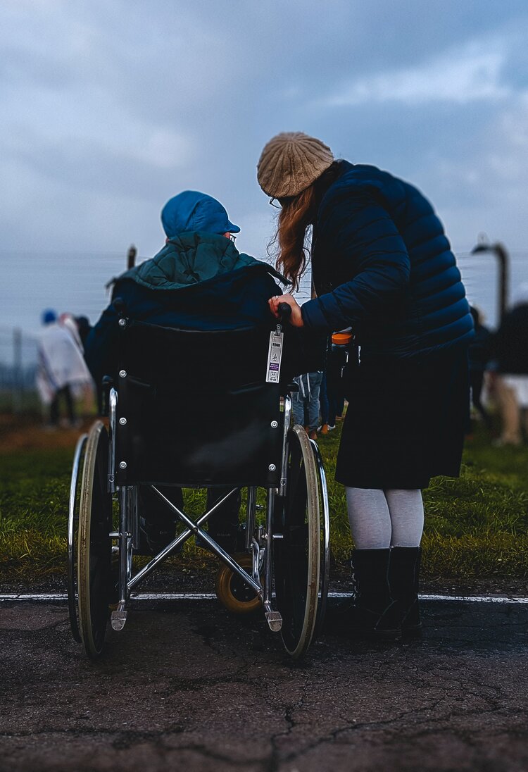 Eine Frau steht neben einem Mann, der im Rollstuhl sitzt | © Josh Appel/unsplash