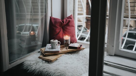 Ein Platz zum ausspannen mit Kakao, Kerze und einem Buch. | © Alisa Anton/unsplash