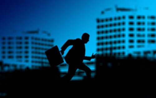 Silhouette eines Manns mit Aktenkoffer und im Hintergrund Bürogebäude | © pixabay