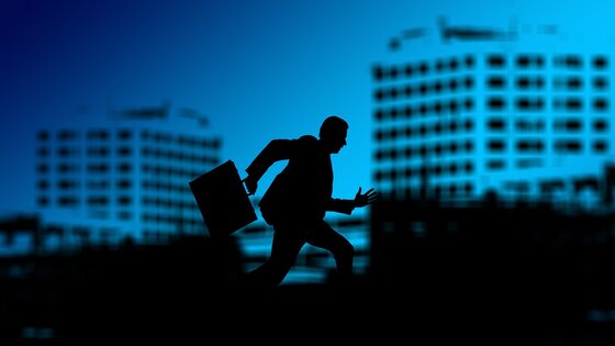 Silhouette eines Manns mit Aktenkoffer und im Hintergrund Bürogebäude | © pixabay