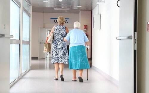 Krankenhausflur auf dem zwei Frauen unterwegs sind. Die ältere Dame benutzt dabei einen Gehstock und hat ihren freien Arm unter den der anderen Frau eingehakt.  | © pixabay