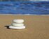 aufeinander gestapelte Steine in verschiedenen Größen an einem Strand mit dem Meer im Hintergrund. | © pixabay