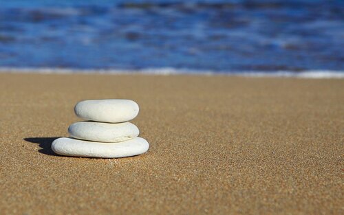 aufeinander gestapelte Steine in verschiedenen Größen an einem Strand mit dem Meer im Hintergrund. | © pixabay