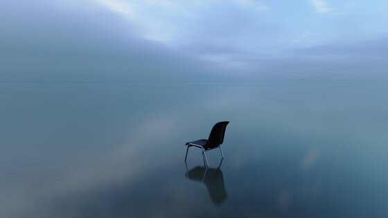Ein Stuhl steht in einem See, umgeben von Wolken und Nebel. | © EnableMe