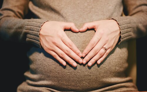 eine schwangere Frau hält ein mit den Händen geformtes Herz vor ihren Bauch | © Suhyeon Choi / Pixabay