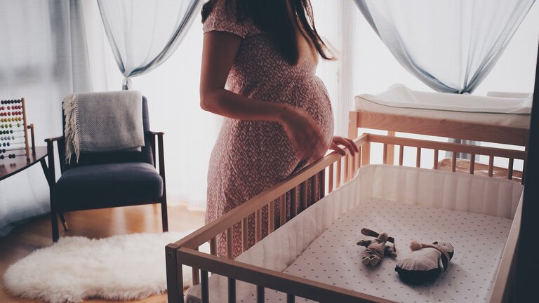 eine schwangere Frau steht neben einem Baby-Gitterbett | © Ömürden Cengiz / Pixabay