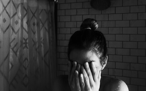 Foto von einer Frau in der Dusche, die sich die Hände vor das Gesicht hält. | © Unsplash