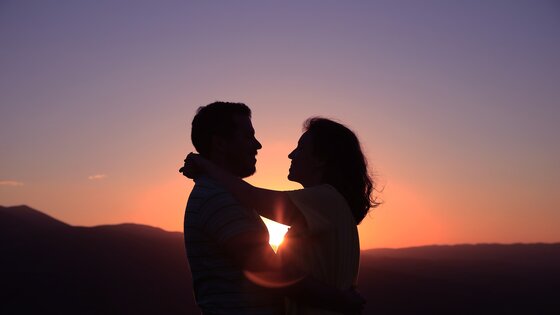 Mann und Frau umarmen sich, im Hintergrund ein Sonnenuntergang | © pixabay