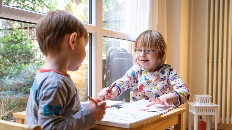 Zwei Kinder lernen lachend an einem Tisch | © Andi Weiland/Gesellschaftsbilder.de