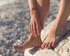 Füße und Hände einer Person am Strand | © Jan Romero/unsplash