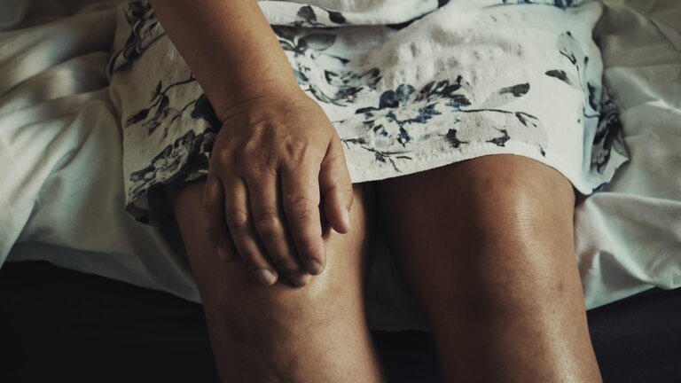 Eine Frau hat ihre Hand auf ihr Knie gelegt | © Anna Auza/unsplash