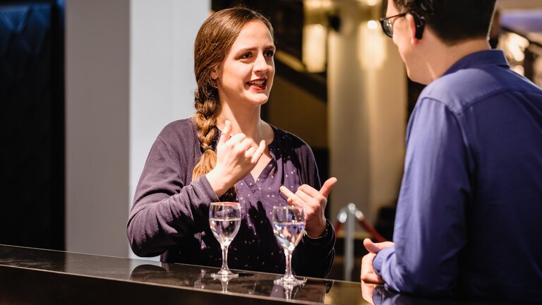 ein Paar spricht in Gebärdensprache an einer Bar | © Andi Weiland/Gesellschaftsbilder.de