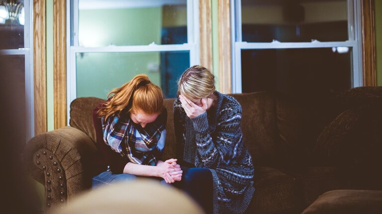 zwei Frauen weinen zusammen auf einem Sofa | © Ben White/unsplash