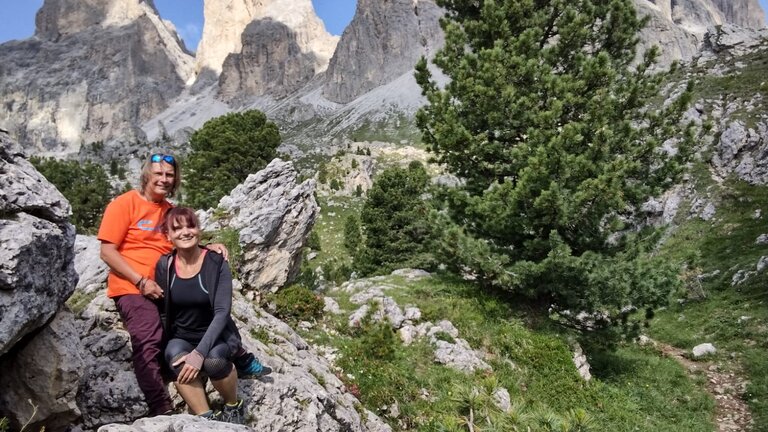 Michael und seine Freundin links im Bild sitzen auf einem Felsen. Im Hintergrund eine Berglandschaft. | © Michael Füchsle