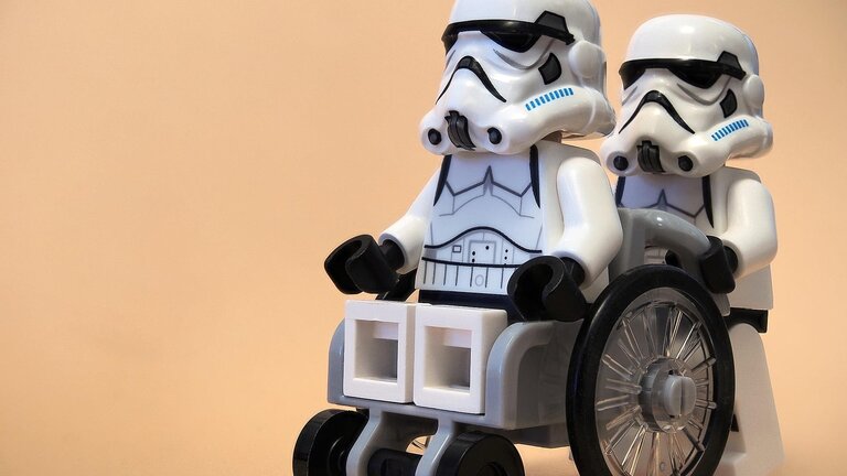 Ein Sturmtruppler aus Star Wars schiebt einen anderen Sturmtruppler im Rollstuhl | © pixabay.de