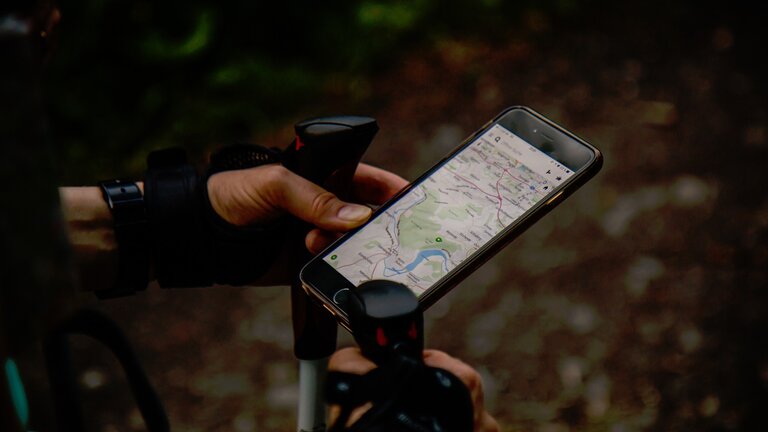 eine Person mit Wanderstöcken nutzt GPS Dunktion am Smartphone | © pixabay