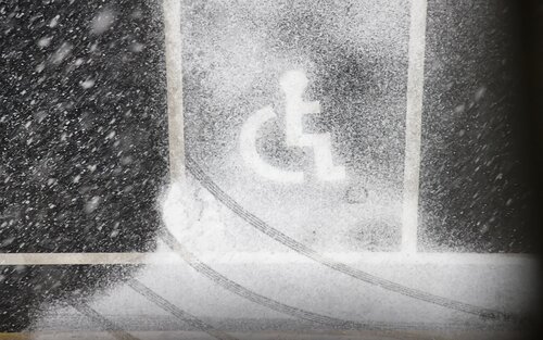 ein Rollstuhl, geformt aus Schnee an einem Fenster | © pixabay