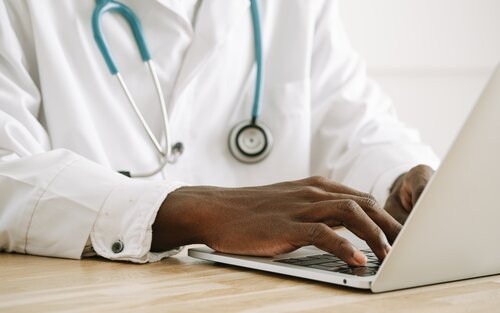 Arzt im weißen Kittel und Stetoskop um den Hals tippt auf einem Laptop | © Ivan Samkov/pixabay.com