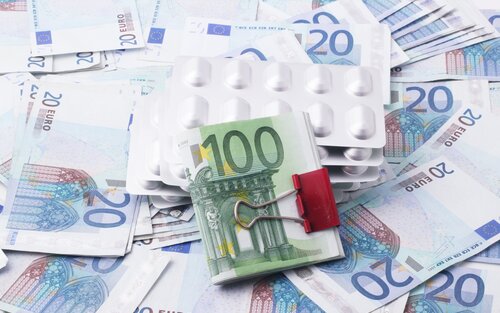 Medikamentenpackungen liegen auf einem Haufen von Geld | © Marek Studzinski/unsplash