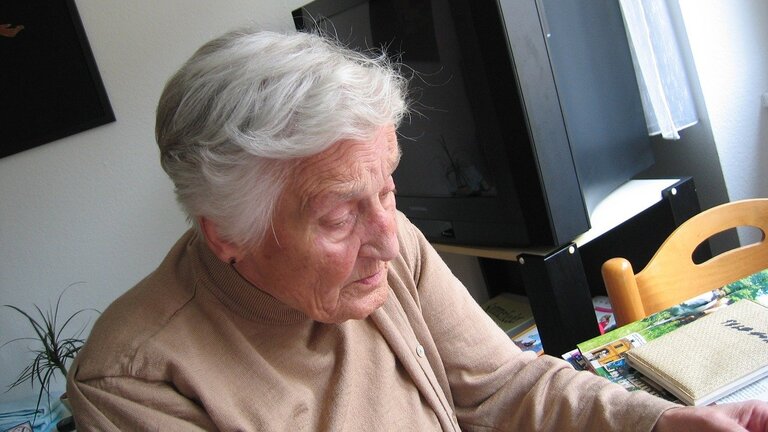 eine ältere Dame sitzt an einem Tisch | © pixabay