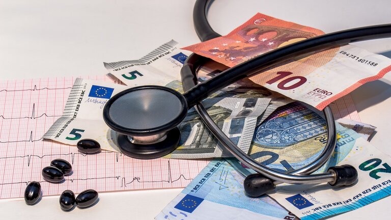 Stethoskop und Tabletten liegen auf Geldscheinen | © pixabay