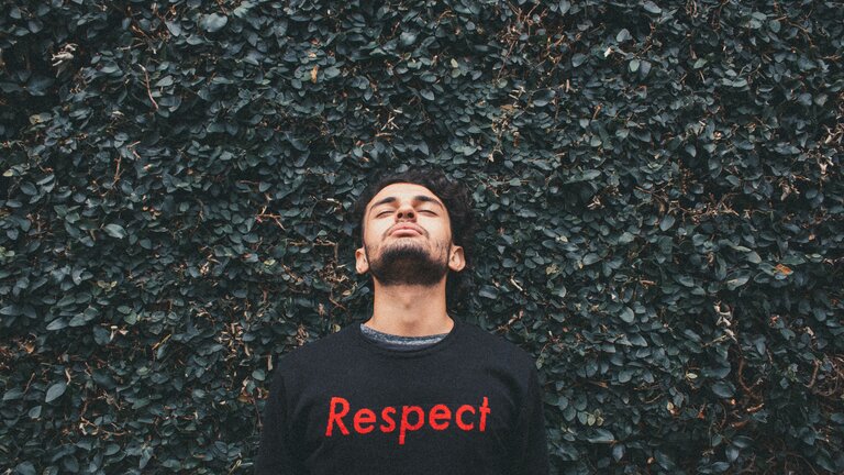 Ein junger Mann trägt einen schwarzen Pulli mit "Respect" | © Tiago Felipe / unsplash