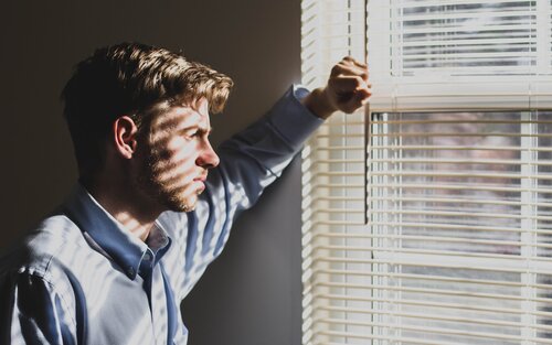 Ein junger Mann sieht nachdenklich zum Fenster hinaus | © unsplash
