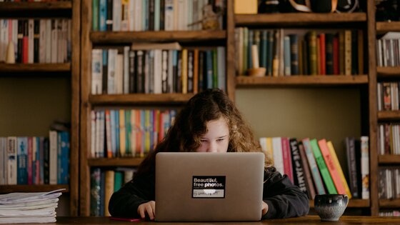 Ein Mädchen sitzt am Schreibtisch und arbeitet am Laptop | © Annie Spratt / unsplash