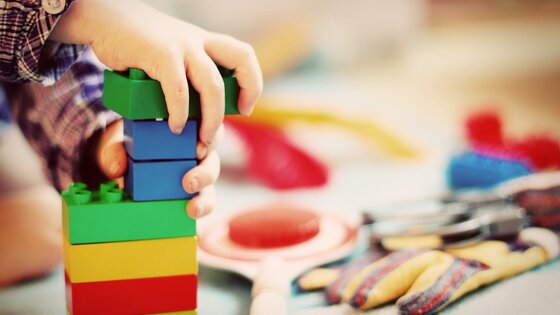 Kinderhände bauen einen Turm mit Bausteinen. | © pixabay.com