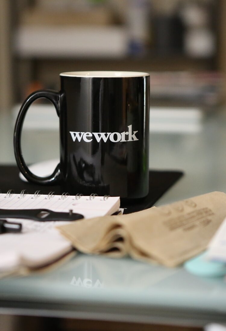 Arbeitsplatz mit Kaffeebecher "wework" | © unsplash