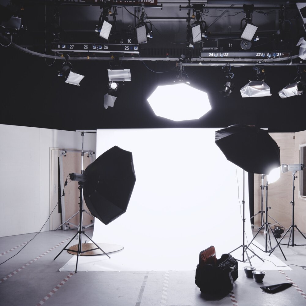 Ein Set für ein Fotoshooting vor weißem Hintergrund mit vielen Schweinwerfern | © unsplash