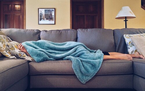 Jemand liegt auf der Couch mit einer Decke über den Kopf | © pexels.com