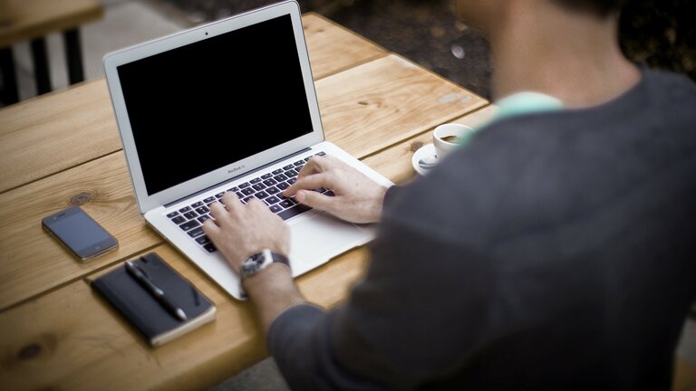 Ein Mann sitzt vor einem Laptop und schreibt etwas | © pixabay.com