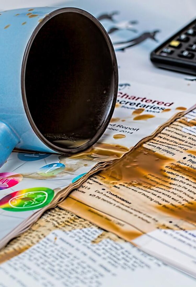 eine umgestoßene Kaffeetasse liegt auf Zeitschriften | © pixabay.com
