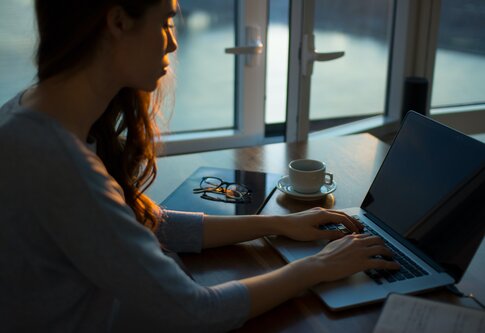 Eine Frau arbeitet am Laptop im halbdunklem. | © unsplysh.com