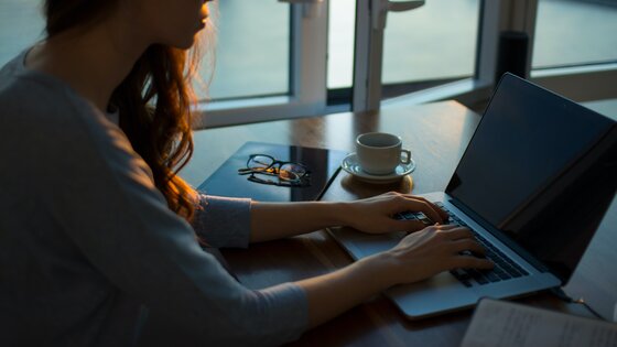 Eine Frau arbeitet am Laptop im halbdunklem. | © unsplysh.com