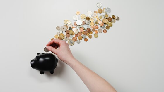 in ein schwarzes Sparschwein werden Münzen eingeworfen | © cottonbro/ pexels.com