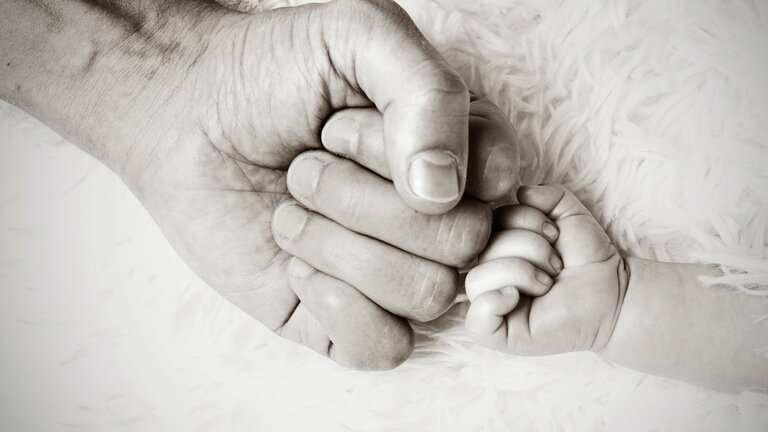 Die Fäuste von Vater und Neugeborenes berühren sich | © Heike Mintel / unsplash