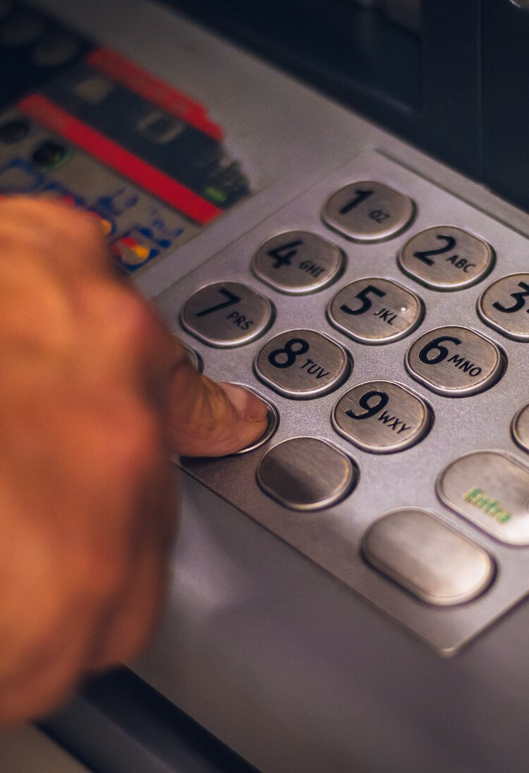 Nahaufnahme von einer Hand, die Zahlen an einem Geldautomat drückt. | © Eduardo Soares/ unsplash