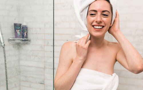 Foto von einer Frau, die aus der Dusche kommt, sie trägt ein weißes Handtuch und einen Turban. | © Unsplash